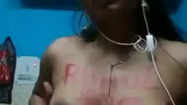 Indian girl with headphones in ears exposes XXX boobies with sex text on