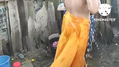 Indian house wife bathing outside