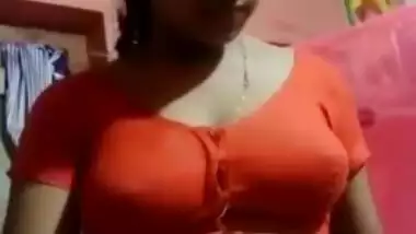 Aroused Desi wife slowly takes red top off to expose boobs for XXX fans