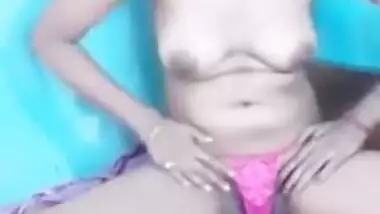 Female sits on bed exposing her XXX boobies and sex slit in Indian video